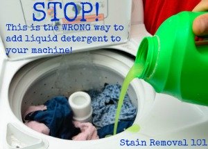 pouring liquid laundry detergent the wrong way, with clothes already in machine